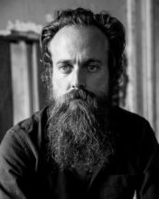 Iron & Wine performing live on stage with guitar