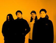 Commoner performing live, intense stage lights, vocalist mid-chorus