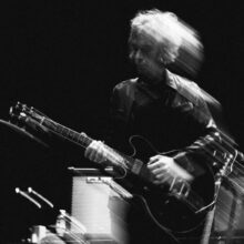Perry Bamonte performing live on stage with The Cure during a concert