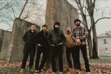 August Burns Red performing live with vocalist Jake Luhrs during a metalcore concert.